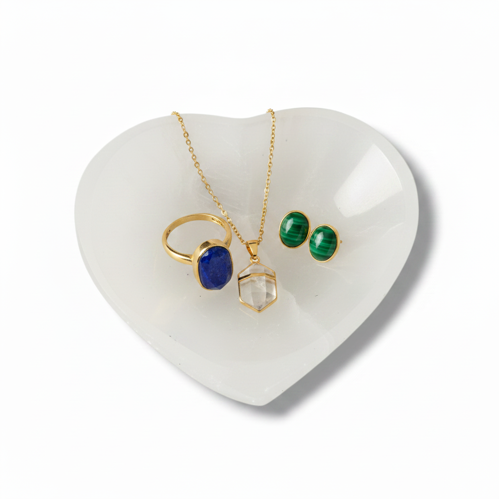 Cuenco corazon de selenita cargando joyería de oro con minerales